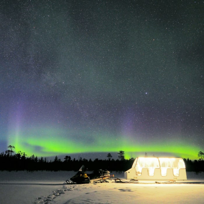 AT Nature's heated glass-roof sleigh under the northern lights.