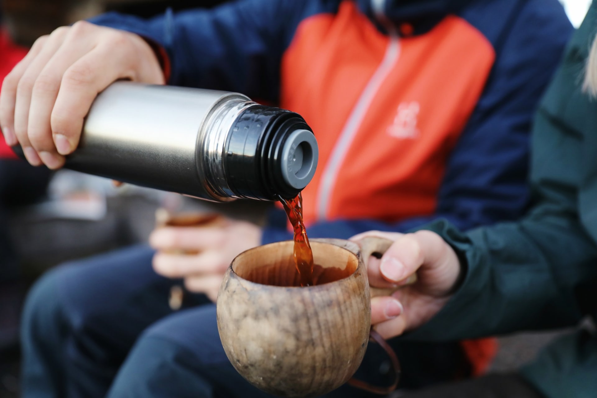 Coffee in nature. Coffee pouring from a thermos into a cup.