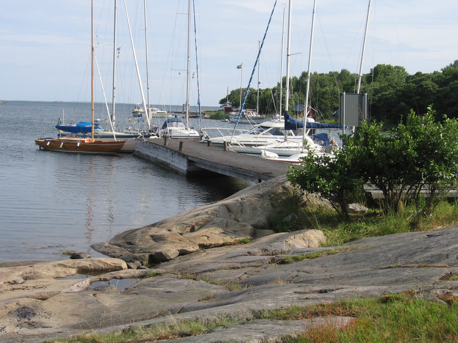 Sataman laituriin on kiinnittynyt kuusi venettä.   Sex båtar ligger förtöjda vid hamnpiren.  Six boats are moored at the harbor pier.