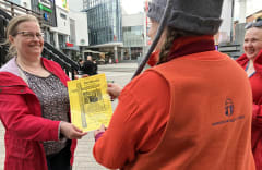 A happy woman receiving a certificate at the Lordi's Square.