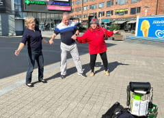 A woman and a man dancing with Good Will Elf at the Lordi's Square.