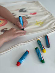 Lapsi piirtämässä kangasliiduilla narureppuun.