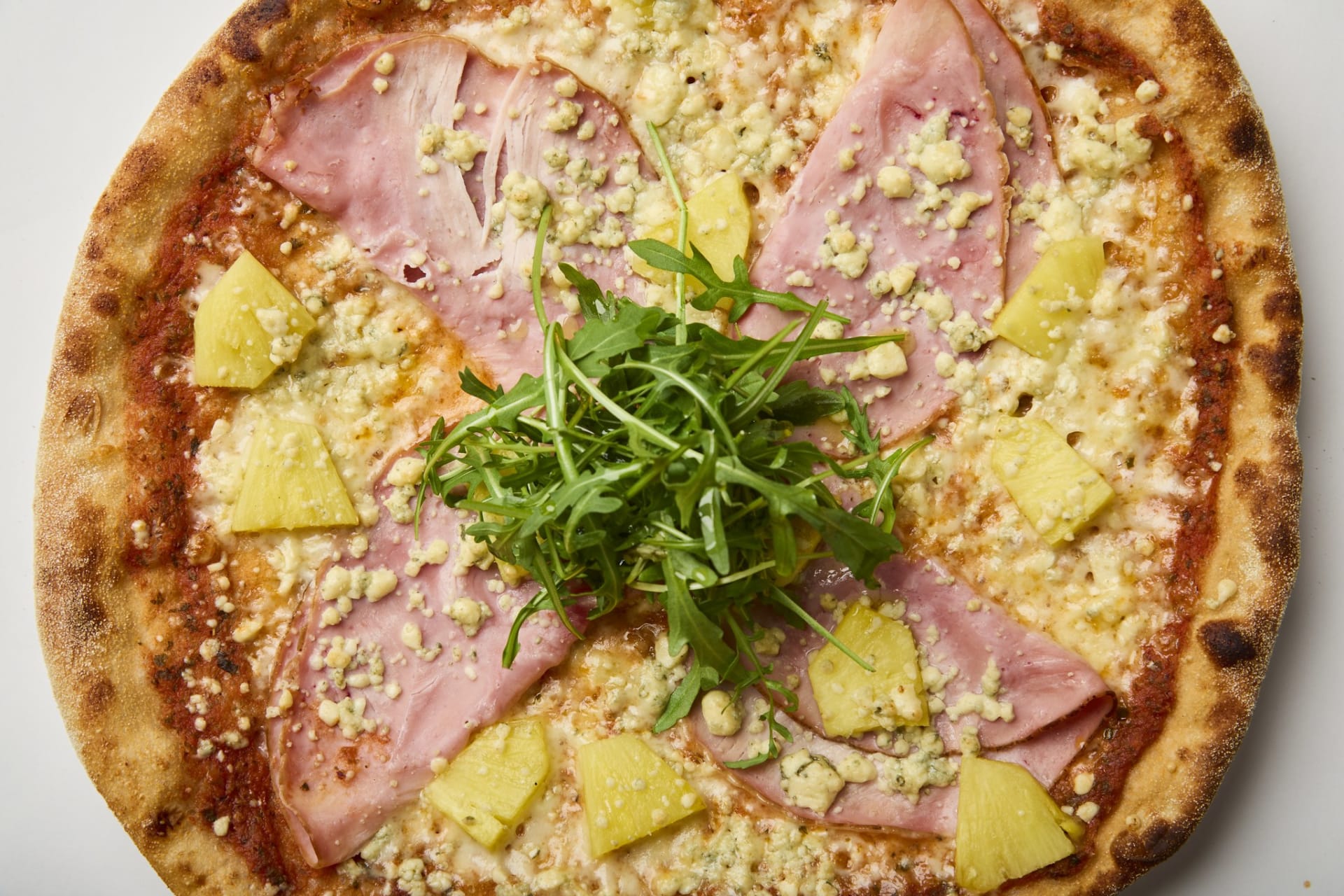 Pineapple leaves no-one cold — Aura blue cheese and pineapple are both flavours that you either like or dislike, but together they create a surprising combination that works with delicious smoked ham and arugula.